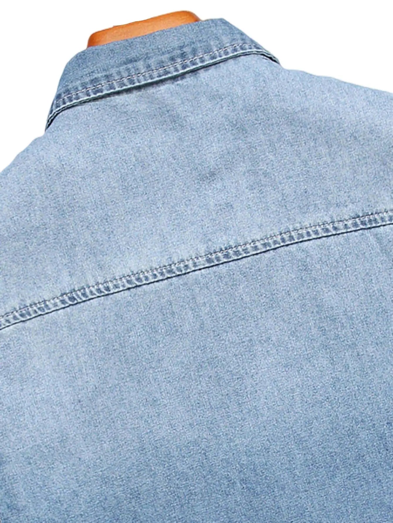 Chemise d'été en jean bleu à manches courtes pour homme, avec détails déchirés. Les détails déchirés soulignent un style tendance et décontracté.