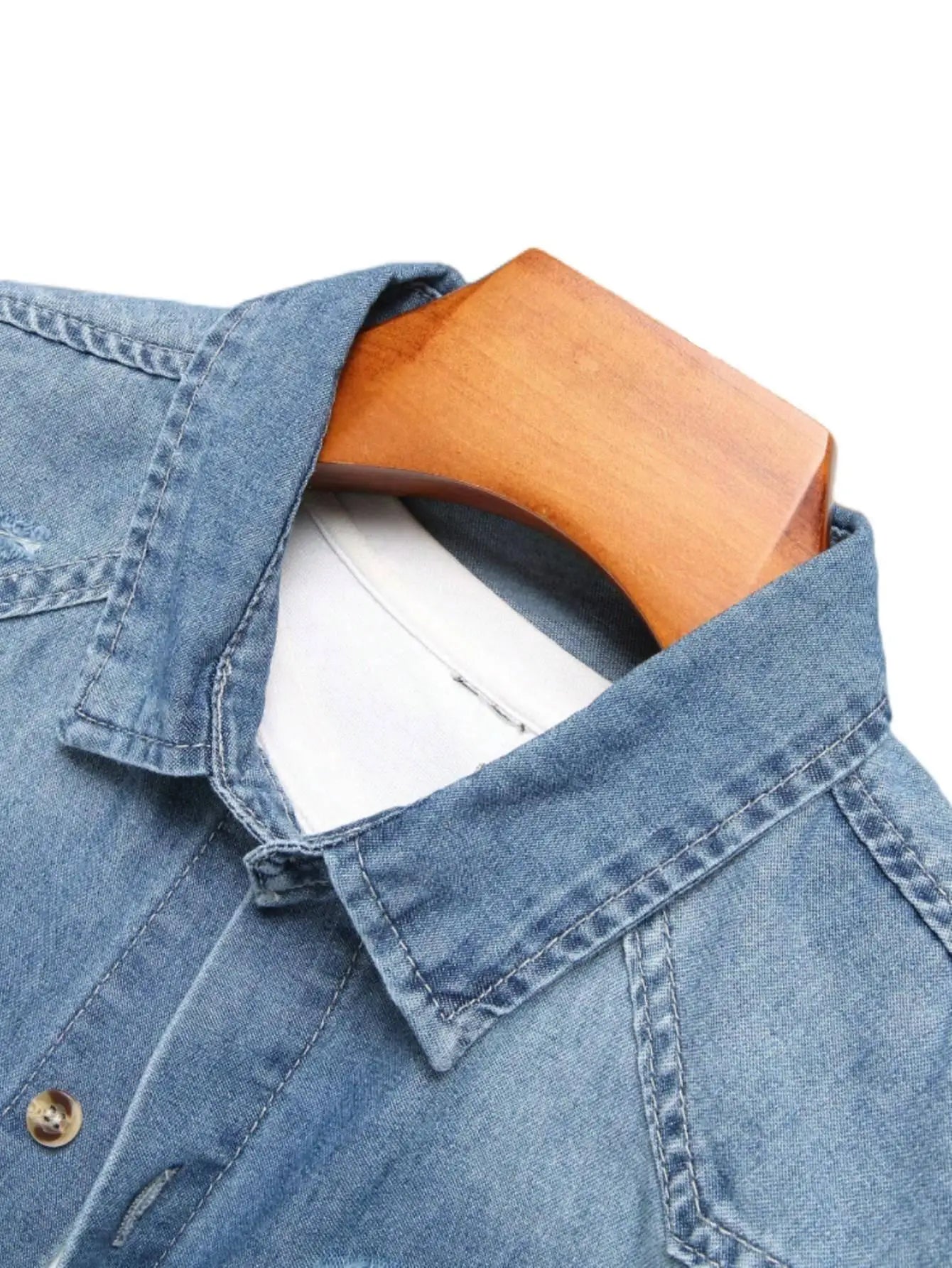 Chemise d'été en jean bleu à manches courtes pour homme, avec détails déchirés. Les détails déchirés soulignent un style tendance et décontracté.