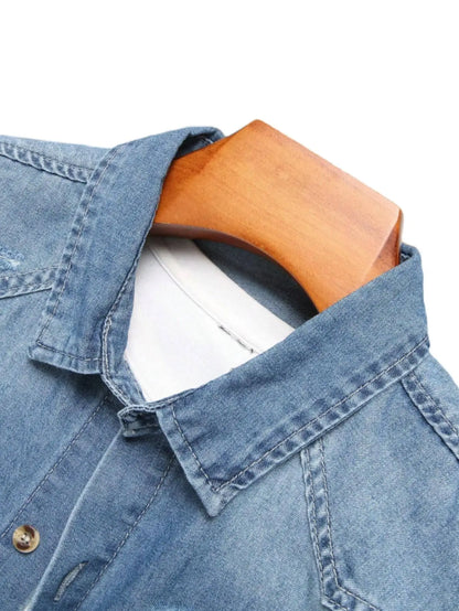 Chemise d'été en jean bleu à manches courtes pour homme, avec détails déchirés. Les détails déchirés soulignent un style tendance et décontracté.